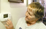 Mary in Monterey adjusts her new thermostat.